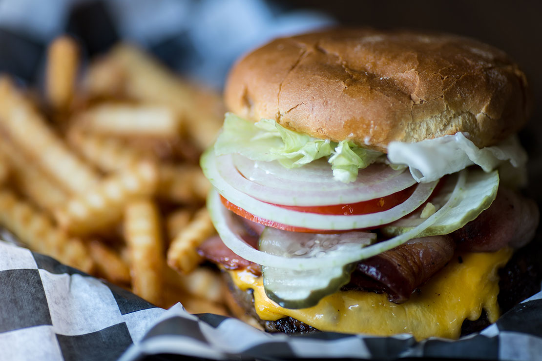 Photo of a delicious burger with fries served at the Custer Crossing Campground's Last Stand Café.